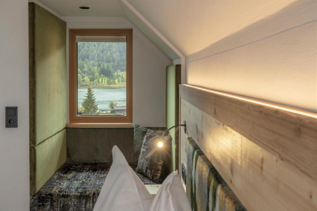 魏森湖Hotel Winkler-Tuschnig的客房设有窗户和长凳,享有美景。