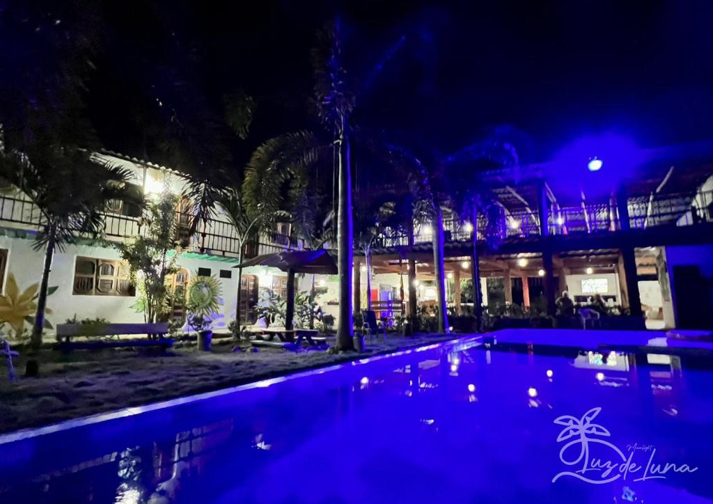 帕洛米诺Hostal Luz de Luna的一座游泳池,在晚上在建筑物前