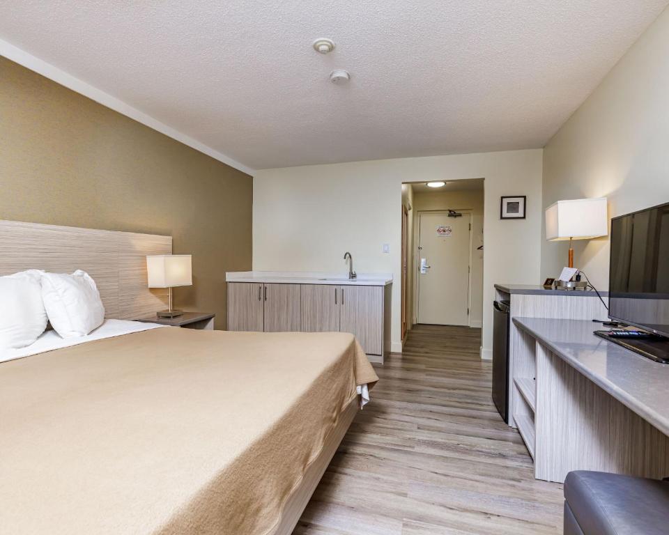 尼亚加拉瀑布Mamma's Inn的配有一张床和一台平面电视的酒店客房