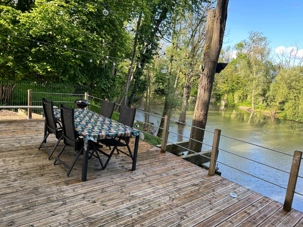 BeloeilÔ Chalet的河边木甲板上的桌椅