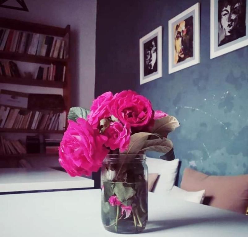 Tlata KetamaKetama trikital的花瓶里满是粉红色的花朵,坐在桌子上