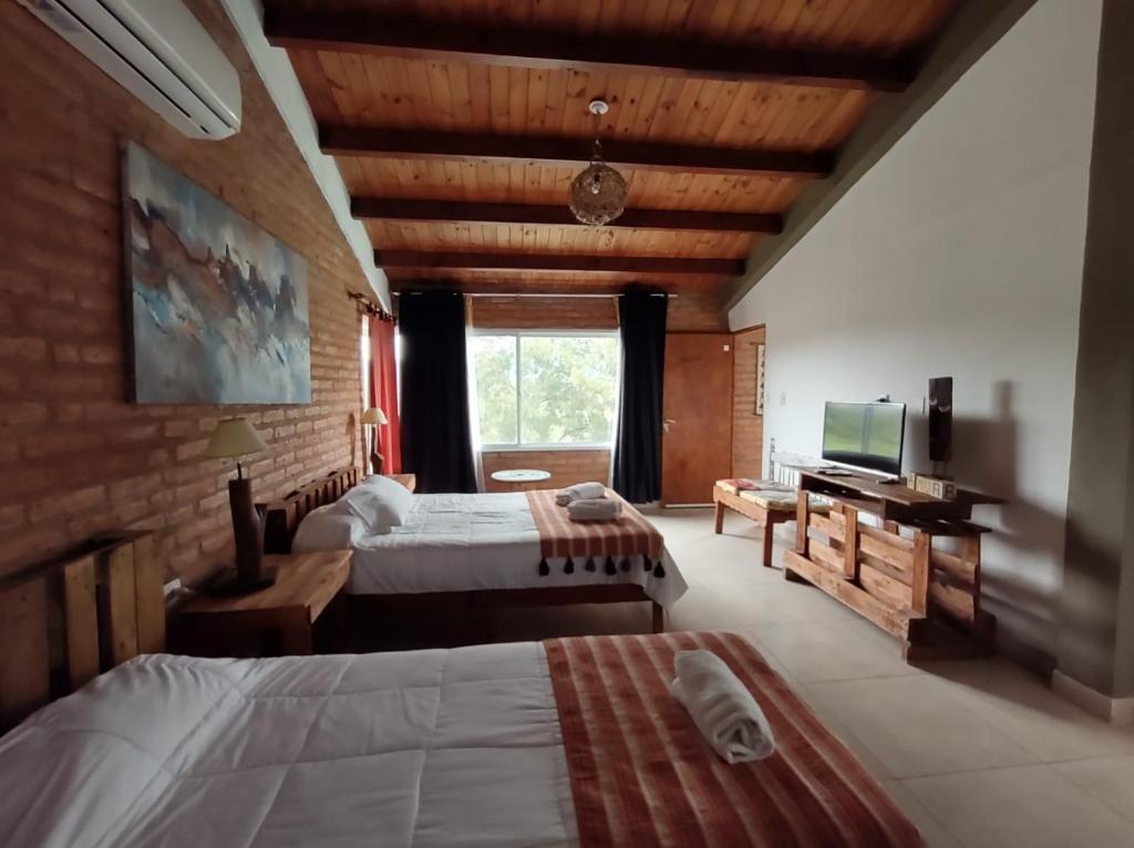 罗萨里奥德拉弗龙特拉Hostería La María的酒店客房设有两张床和电视。