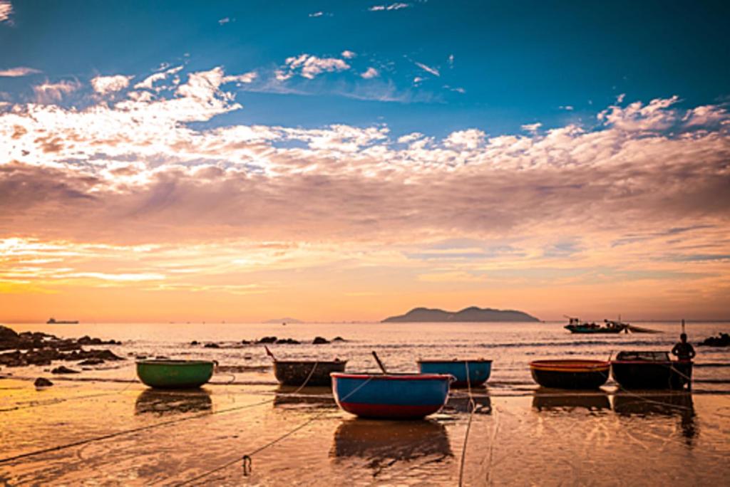 格卢市社Hùng Đức Hotel Cửa Lò的日落时分在海滩上坐的一群船