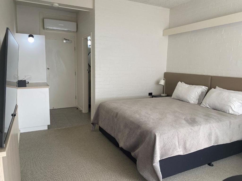 多伦多Toronto Hotel的一间卧室设有一张床和白色的墙壁