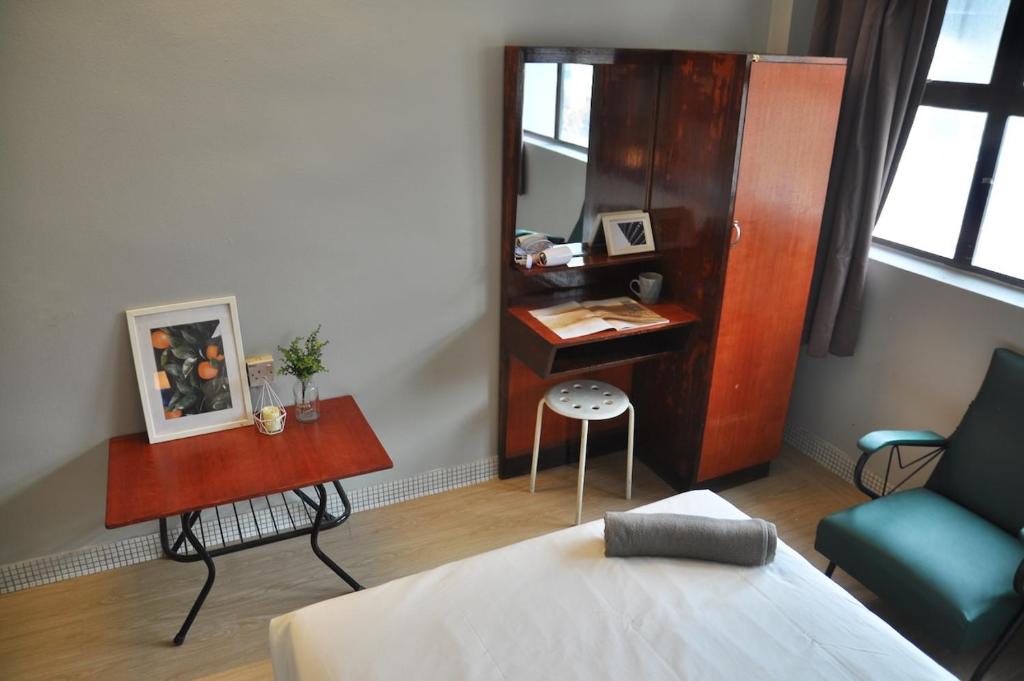 怡保GRAYHAUS INN Ipoh的一间卧室配有书桌、一张床和一把椅子