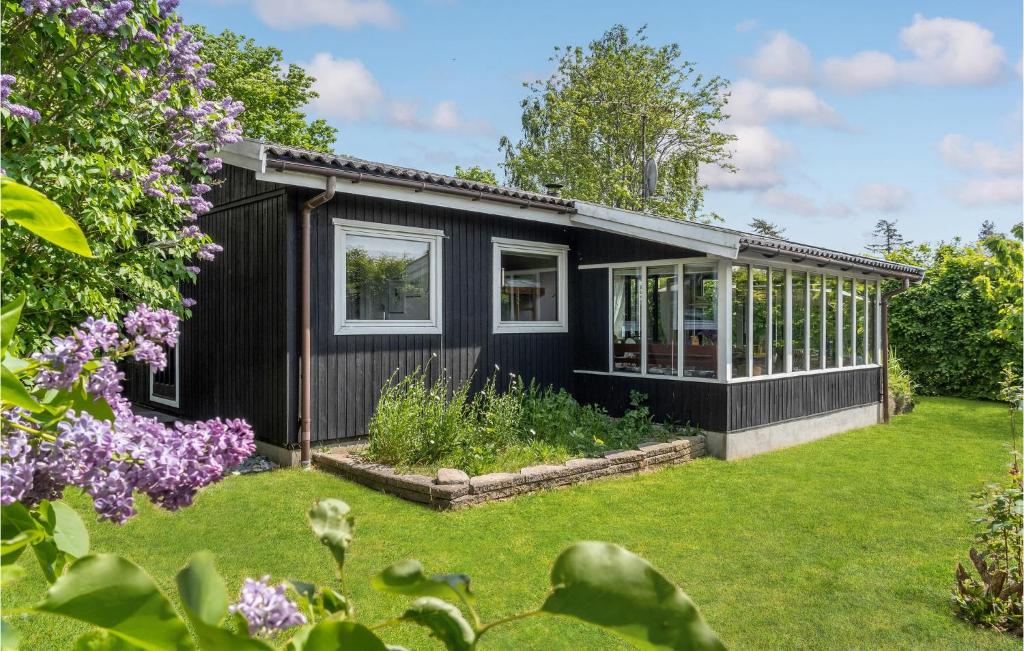 Bogø ByStunning Home In Bog By With Kitchen的前面有花园的黑色房子