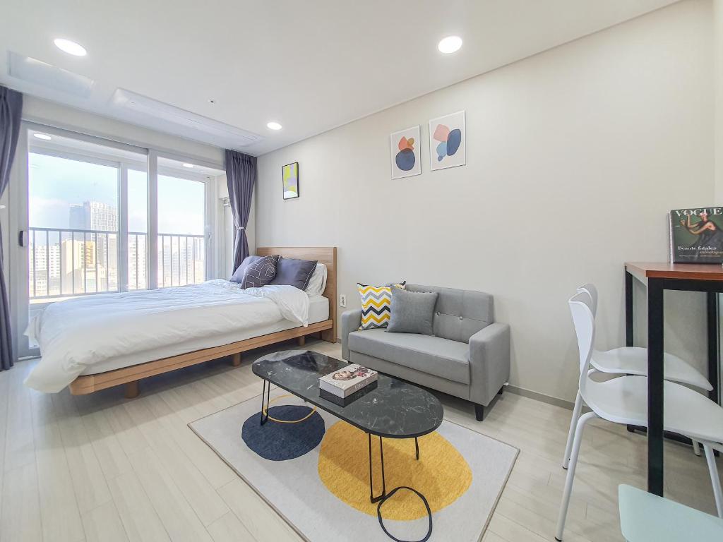 济州市Jeju Centerpoint N Residence的一间卧室配有一张床、一张沙发和一张桌子