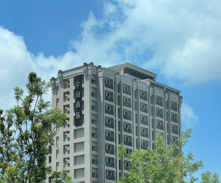 新市 宇田商旅的一座高大的灰色建筑,前沿有树木