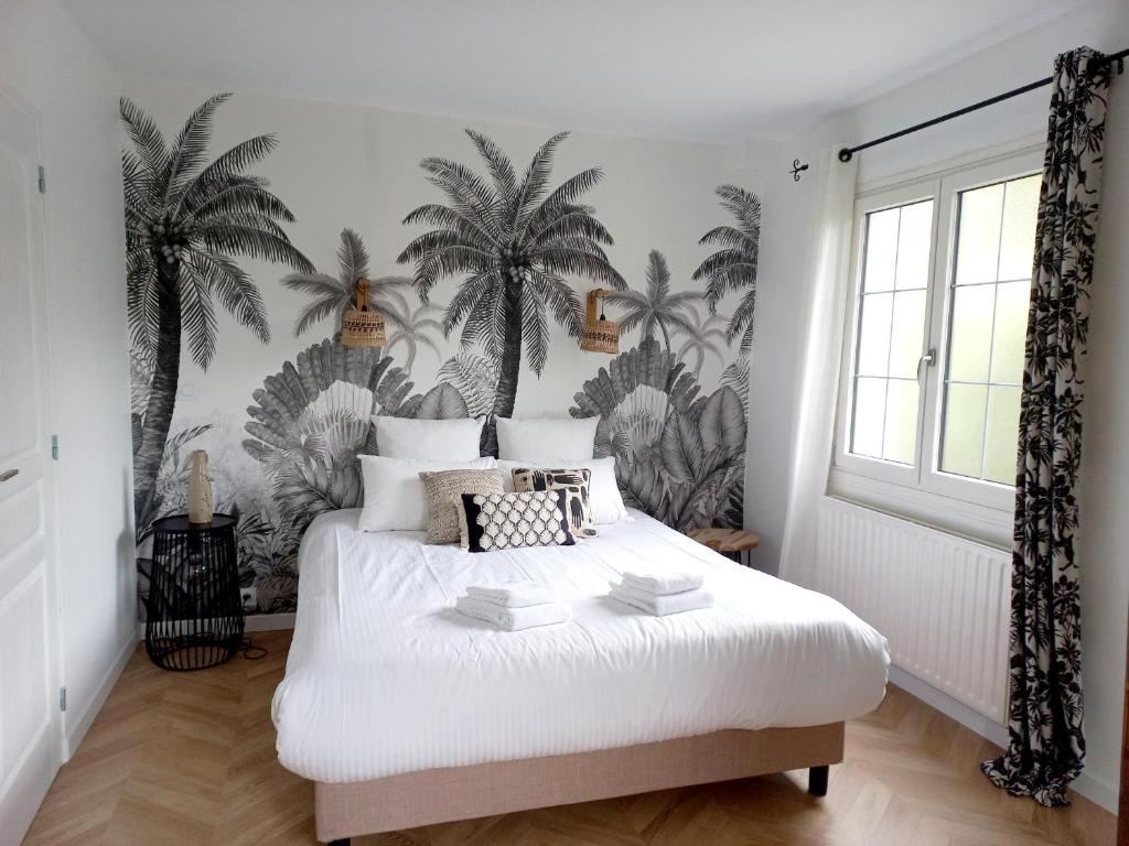 Montjean-sur-LoireLe Clos Beauséjour的卧室配有一张墙上棕榈树床。