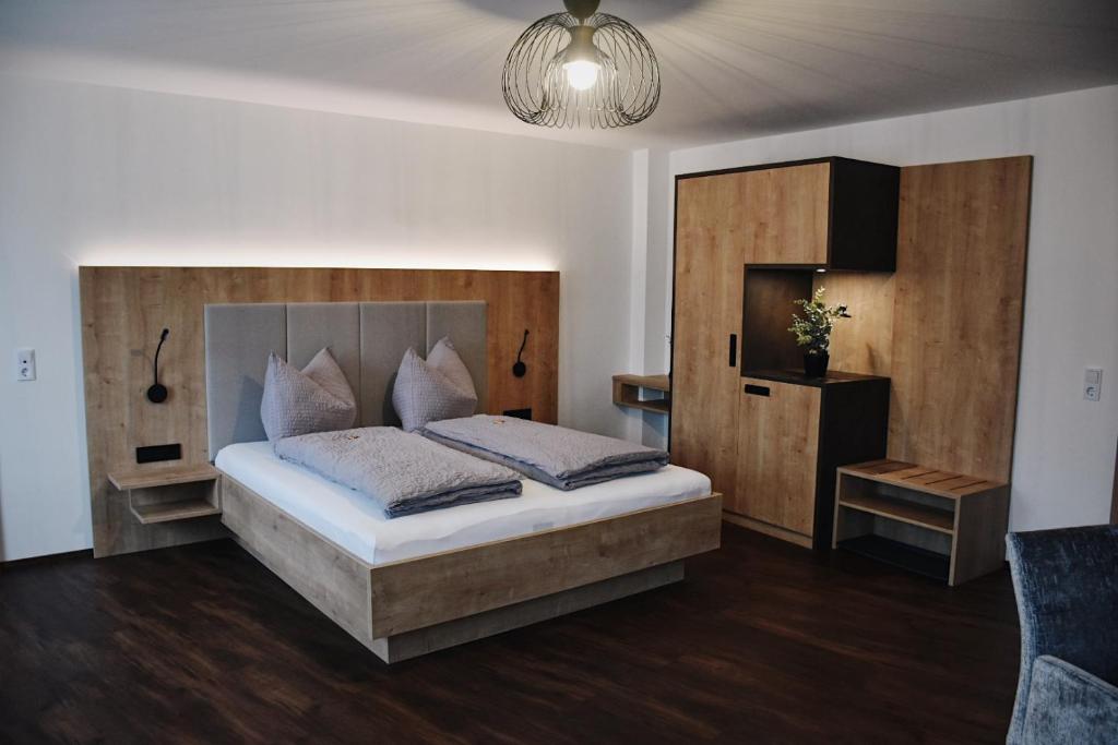 Das Joes Frühstückspension的一间卧室配有一张带木制床头板的床