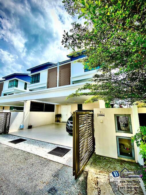 峇都丁宜Batu Ferringhi Luxurious Modern Designed 5BR House的一座白色的大房子,前面有一个门