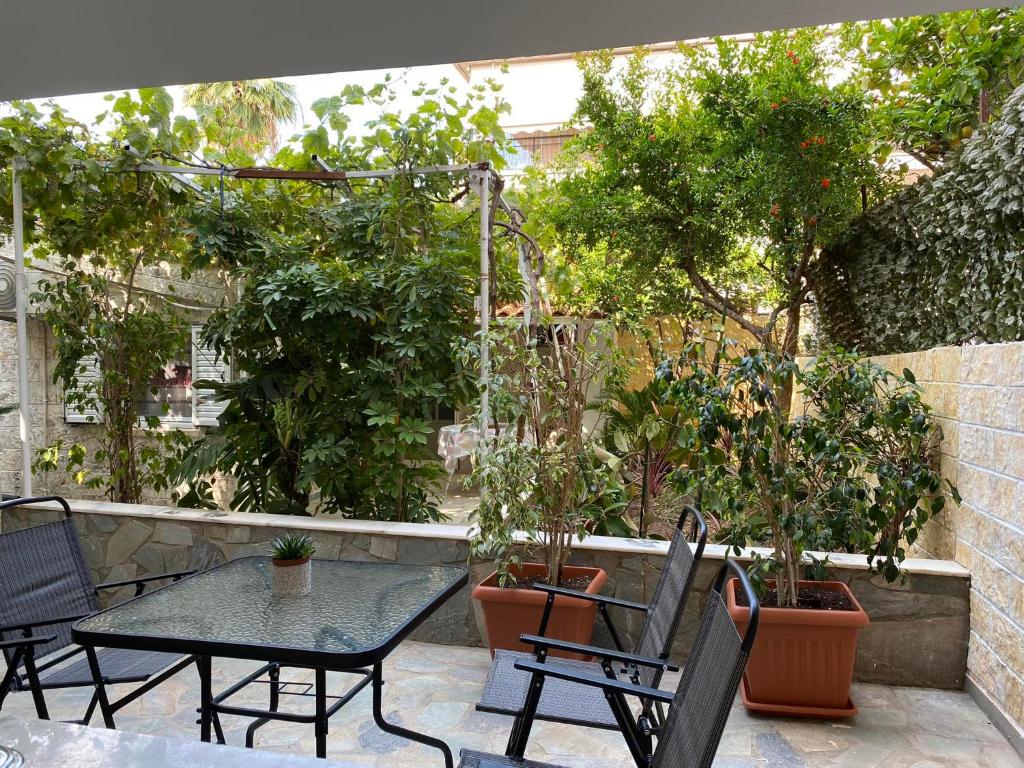 雅典Garden View Apartment的庭院配有桌椅和树木