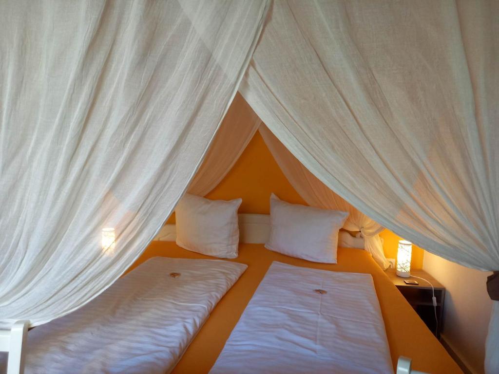 多瑙河畔克雷姆斯奥夫戴尔坤斯特美旅馆的帐篷下的卧室配有两张床