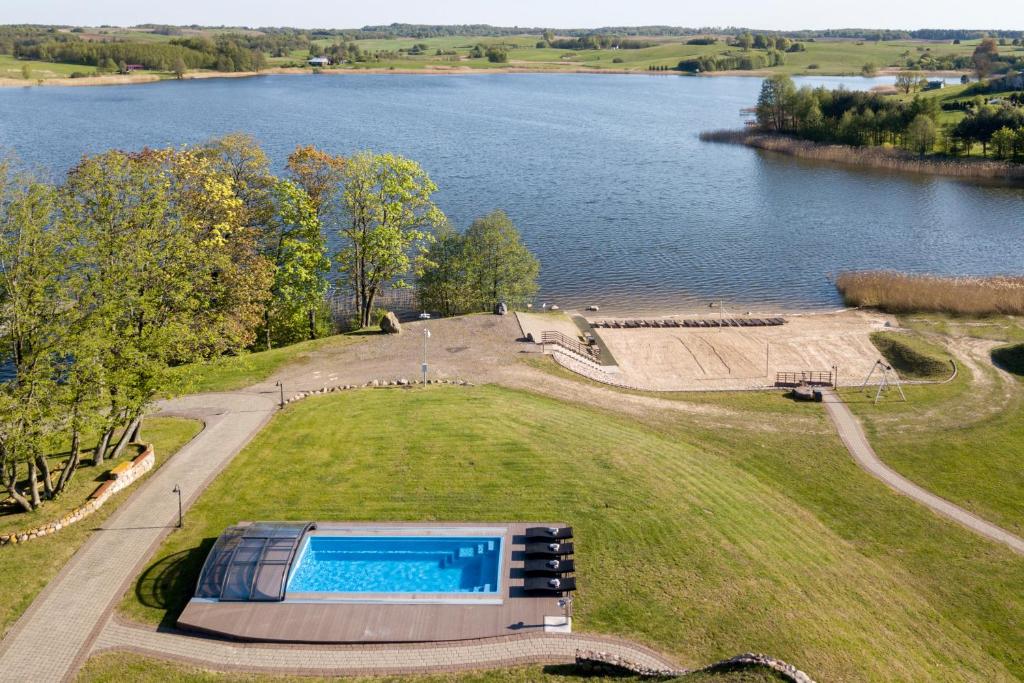 ReketijaReketijos Dvaras的享有游泳池在湖边田野的空中景色