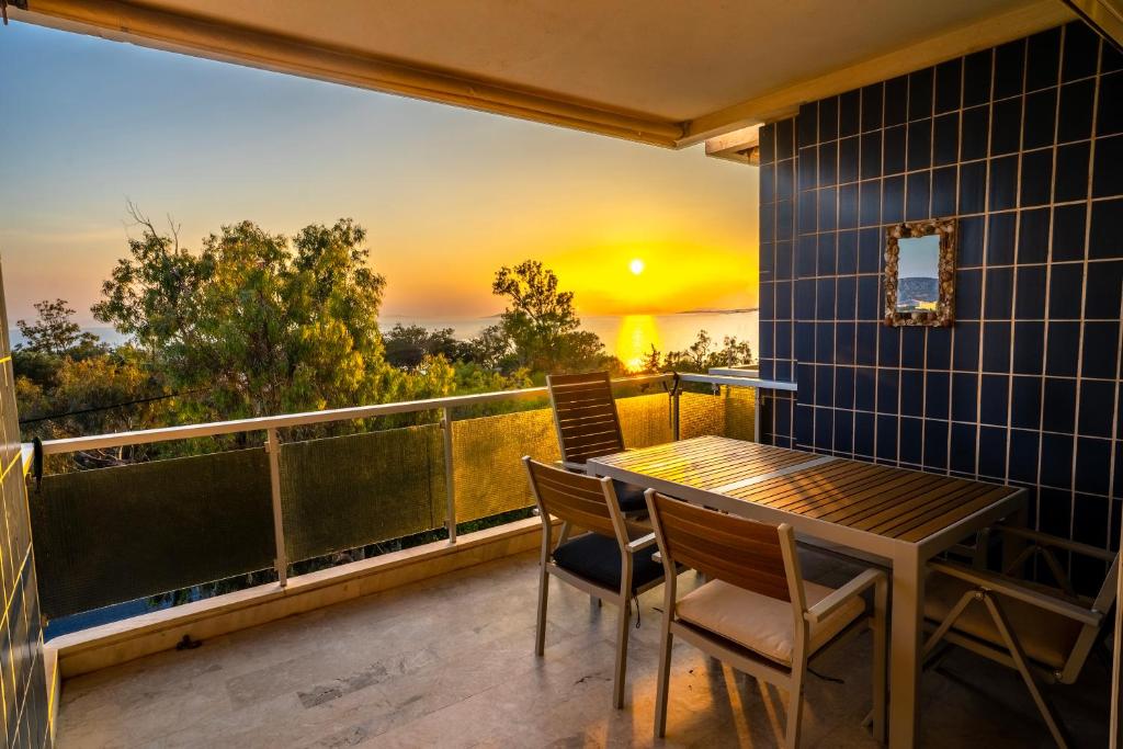 萨罗尼扎Sunset seaview on the coast of Saronida的阳台配有桌椅,享有日落美景。