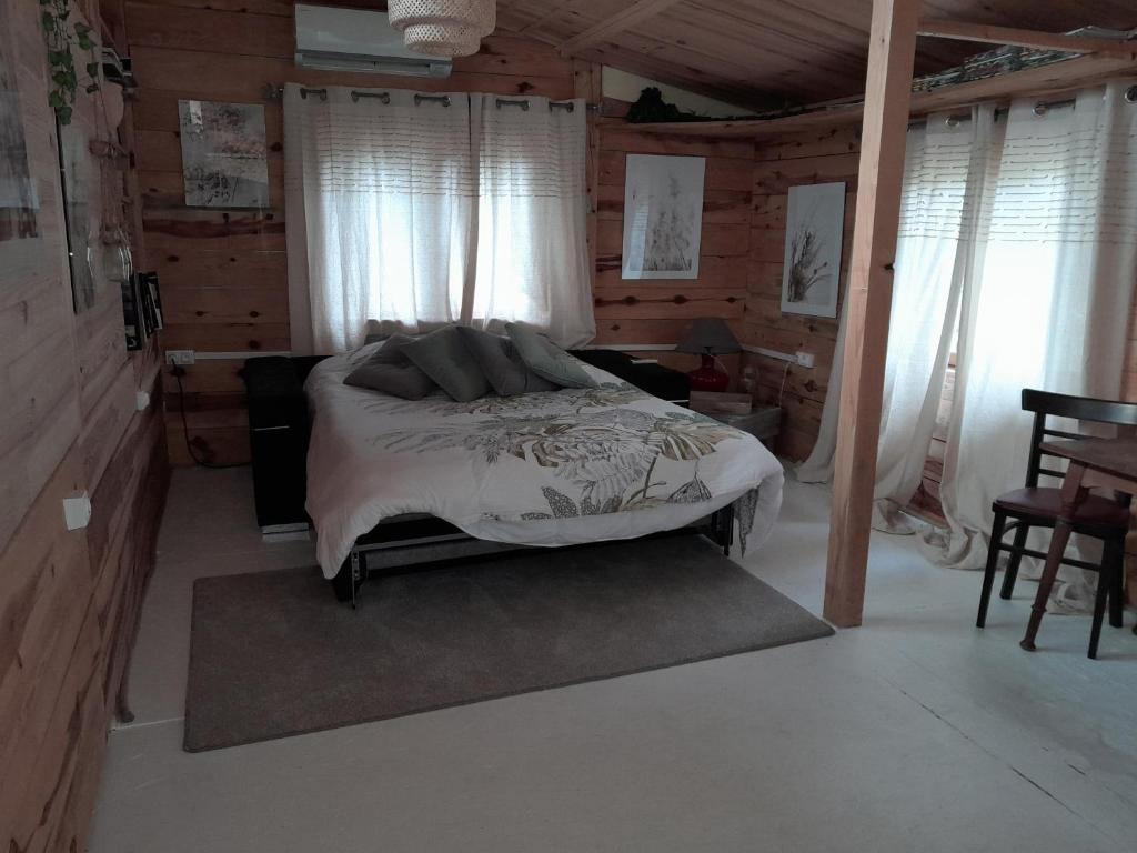 洛尔格Domaine d'Avalon的卧室配有一张床铺,位于带木墙的房间内