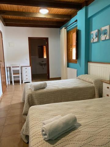 Arens de LledóLA SOCIEDAD的蓝色墙壁客房的两张床