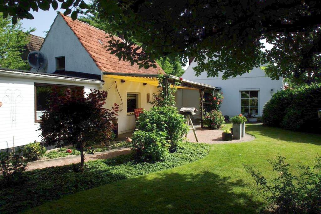 不莱梅Gemütliches Haus mit großem traumhaften Garten的白色的房子,花园,草地庭院