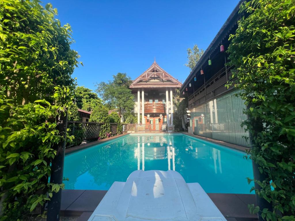 清迈Pha Thai House的一座带凉亭的房子前的游泳池