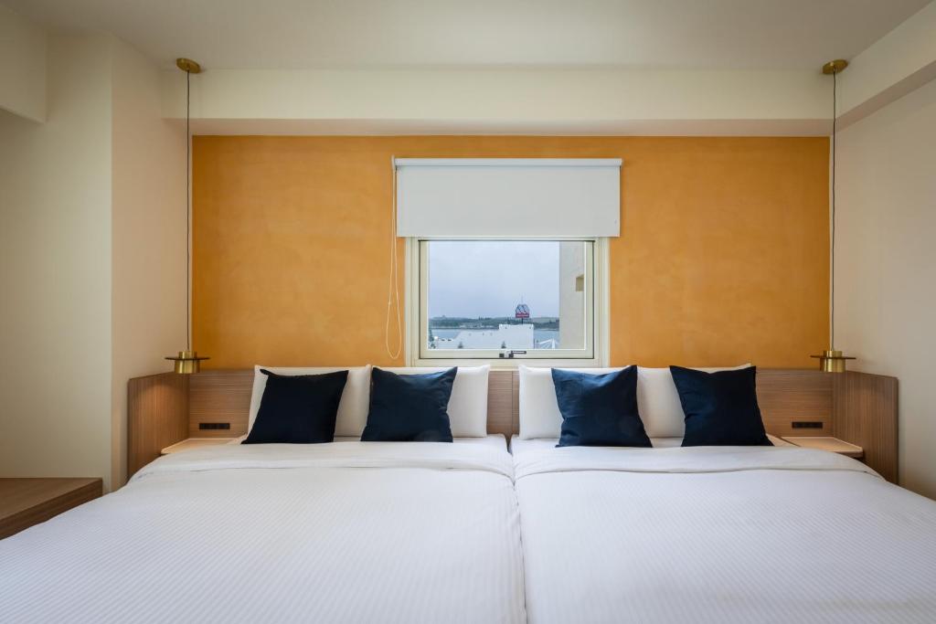 马公澎湖长春大饭店的一间卧室设有一张大床和窗户