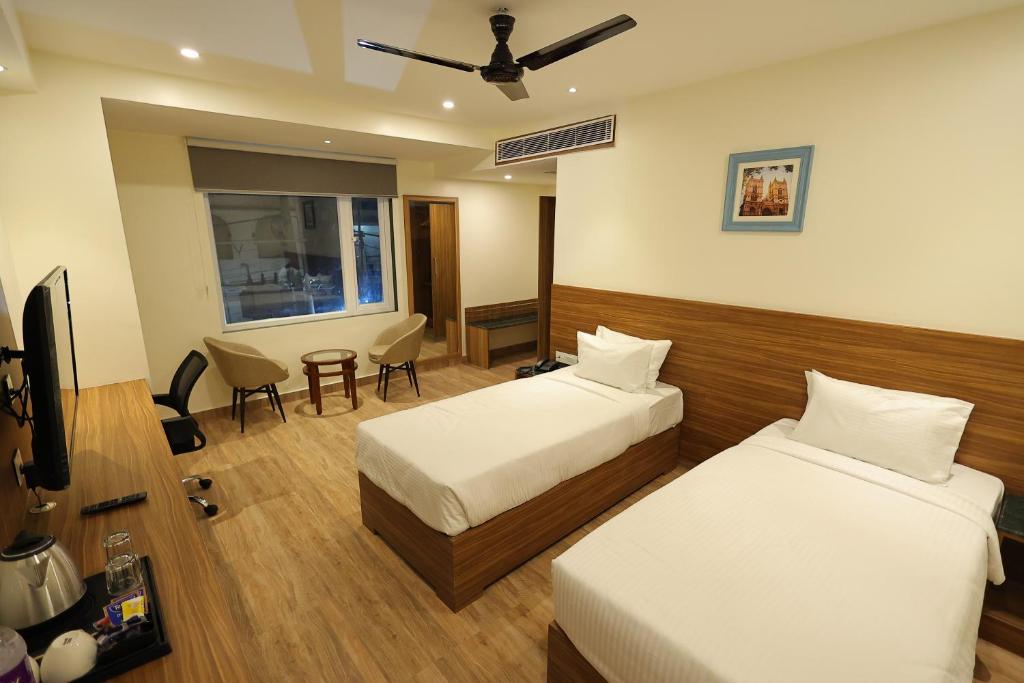 巴特那Hotel Sharda Residency的酒店客房设有两张床和电视。