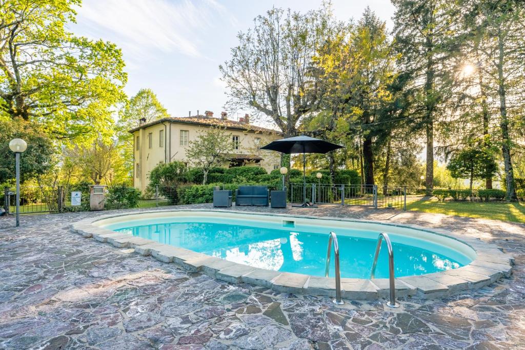 巴尔加Tuscan Skye - Villa Sofia with private swimming pool and garden的房屋前带遮阳伞的游泳池