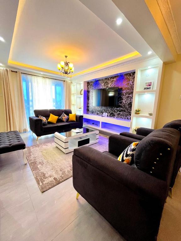 蒙巴萨Nitro Homes Nyali的客厅配有两张沙发和一台电视机