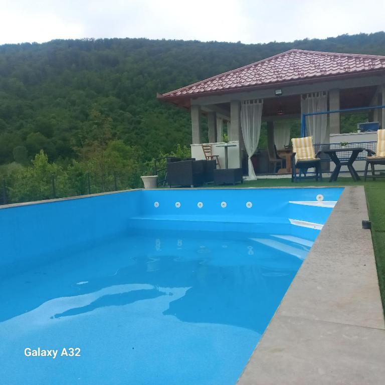 比哈奇Kuća za odmor Lohovo的房子前面的蓝色游泳池