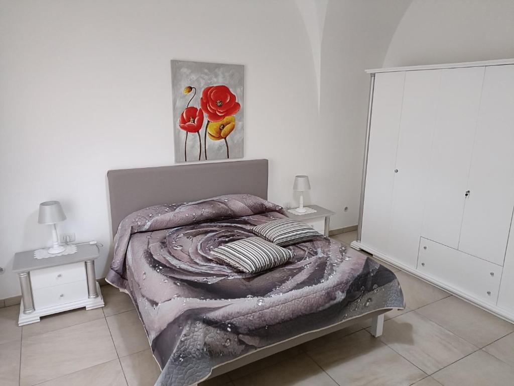 奥里亚LA CASA DEI DESIDERI的一间卧室配有一张床和两张带台灯的桌子。