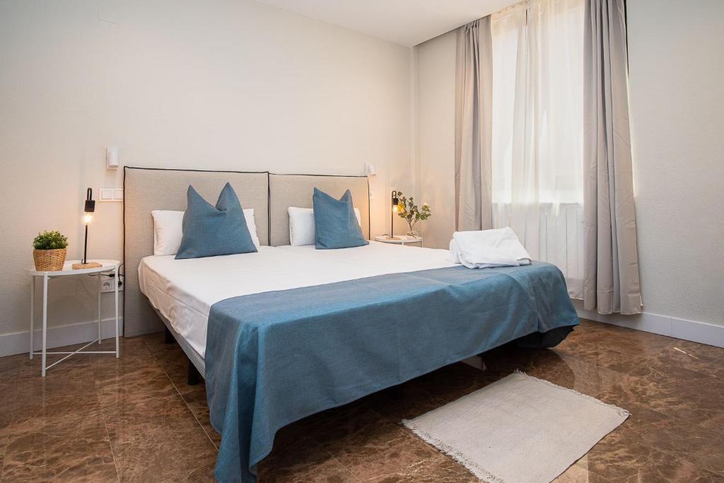 萨拉戈萨AZ Orús Factory Hotel - Parking Gratuíto的一间卧室配有一张带蓝色枕头的大床