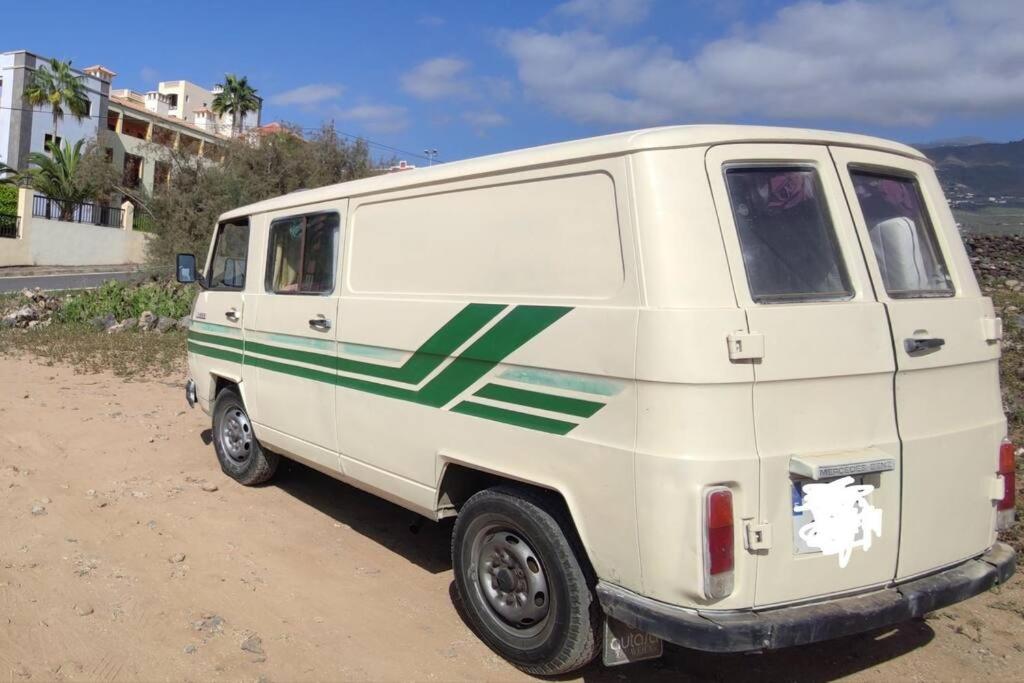 阿德耶Tenerife Van Mercedes for drive in Canary island的一辆绿色条纹的白色面包车停在土路上