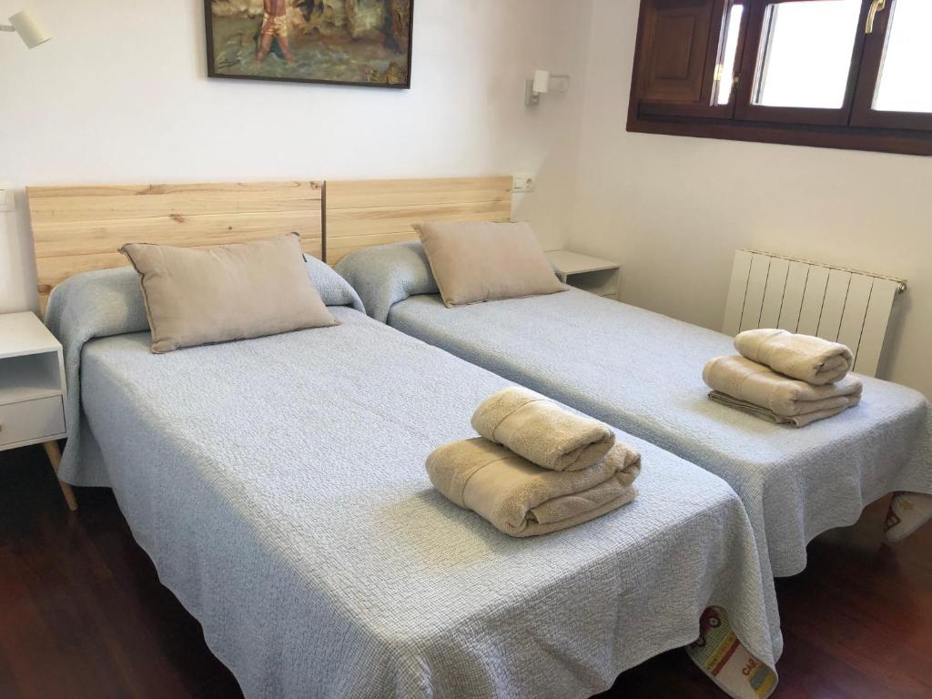 里瓦德塞利亚Casa Mojapies的两张床铺,上面有毛巾
