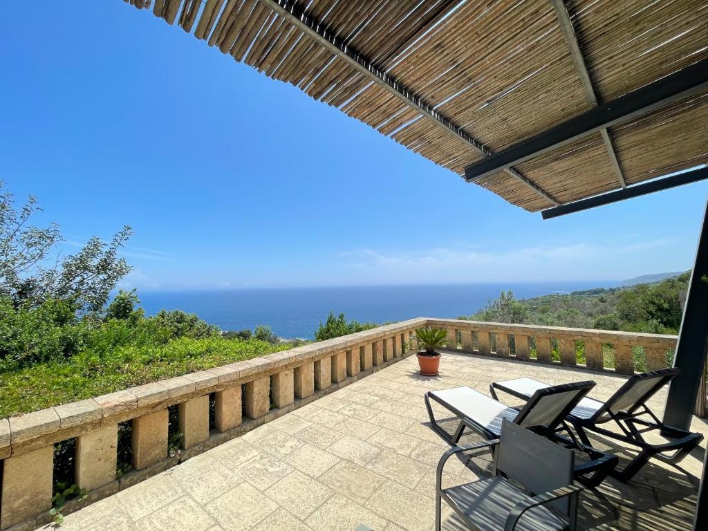 加利亚诺德尔卡波Il Terrazzo - Galatea casa vacanze的一个带两把椅子的庭院和背景海洋