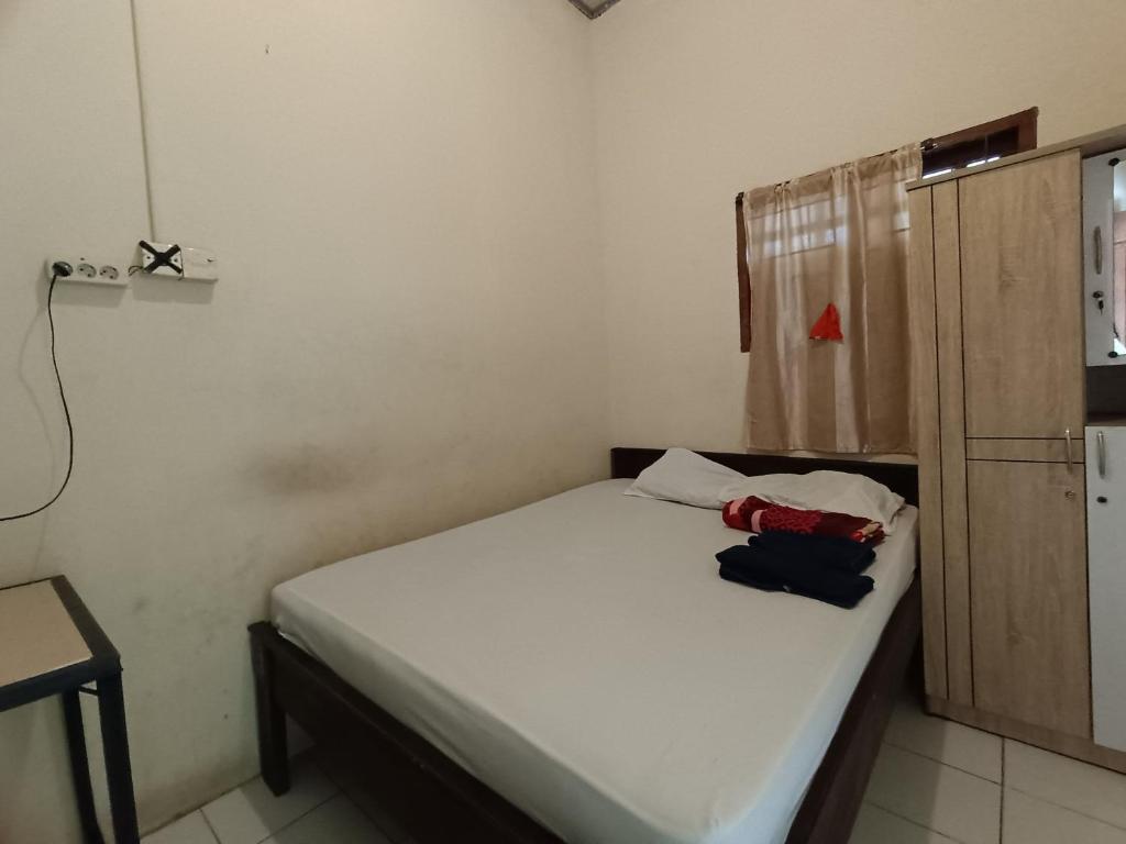 UjungtanjungOYO 92591 Wisma Pangestu Syariah的一间小卧室,配有白色的床和橱柜