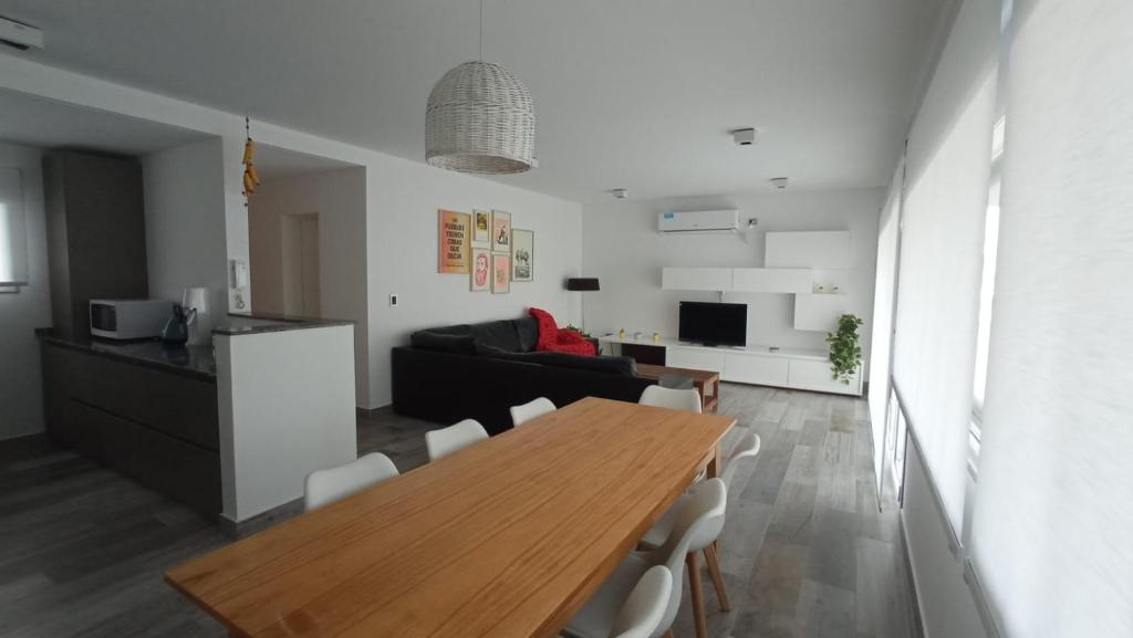 皮拉米德斯港Casa en el mar的厨房以及带木桌和椅子的客厅。