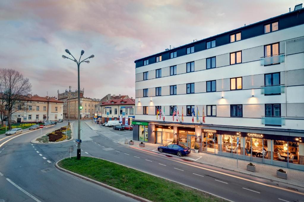 热舒夫B&B HOTEL RZESZÓW CENTRUM的街道上的建筑物,前面有停车位