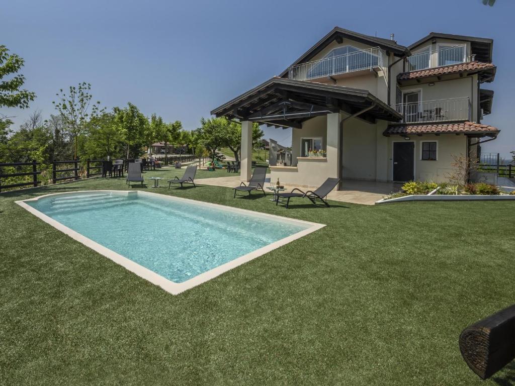 阿斯蒂Casa del Rosmarino的一个带游泳池和房子的庭院