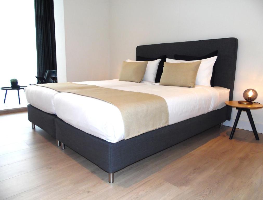 阿姆斯特丹佛兰肯代尔公寓酒店的卧室内的一张带白色床单和枕头的大床