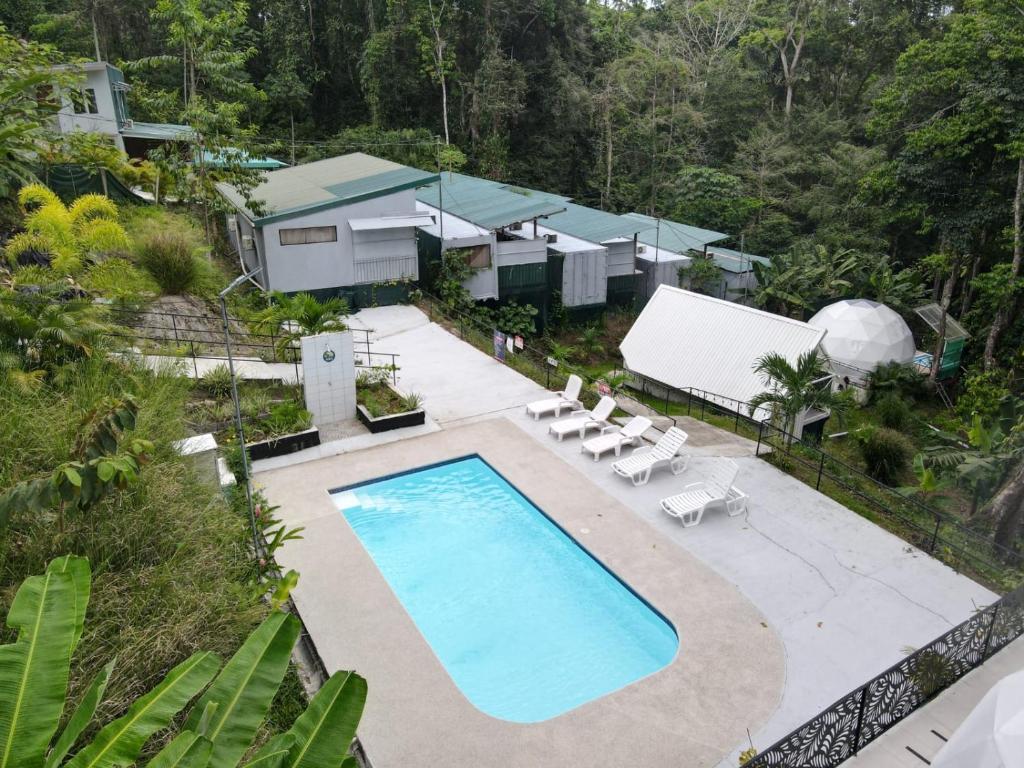 别霍港HOTEL, VILLAS y GLAMPINGS MYA -PUERTO VIEJO, Limon, CR的享有游泳池和房屋的顶部景致
