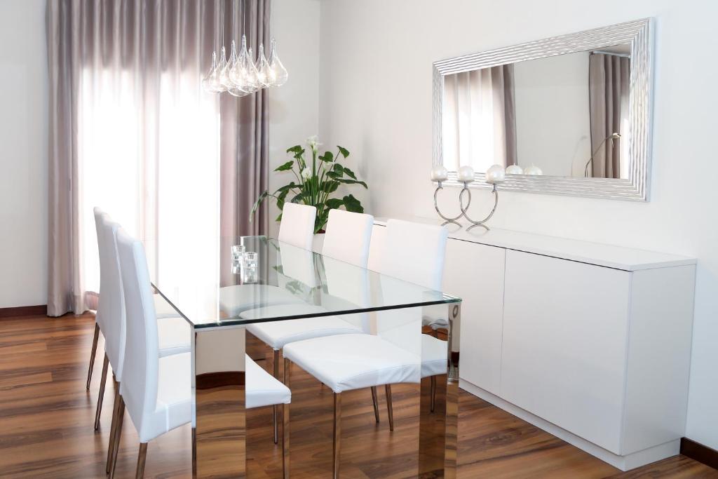 纳扎雷Pôr do Sol II的一间设有玻璃桌和白色椅子的用餐室