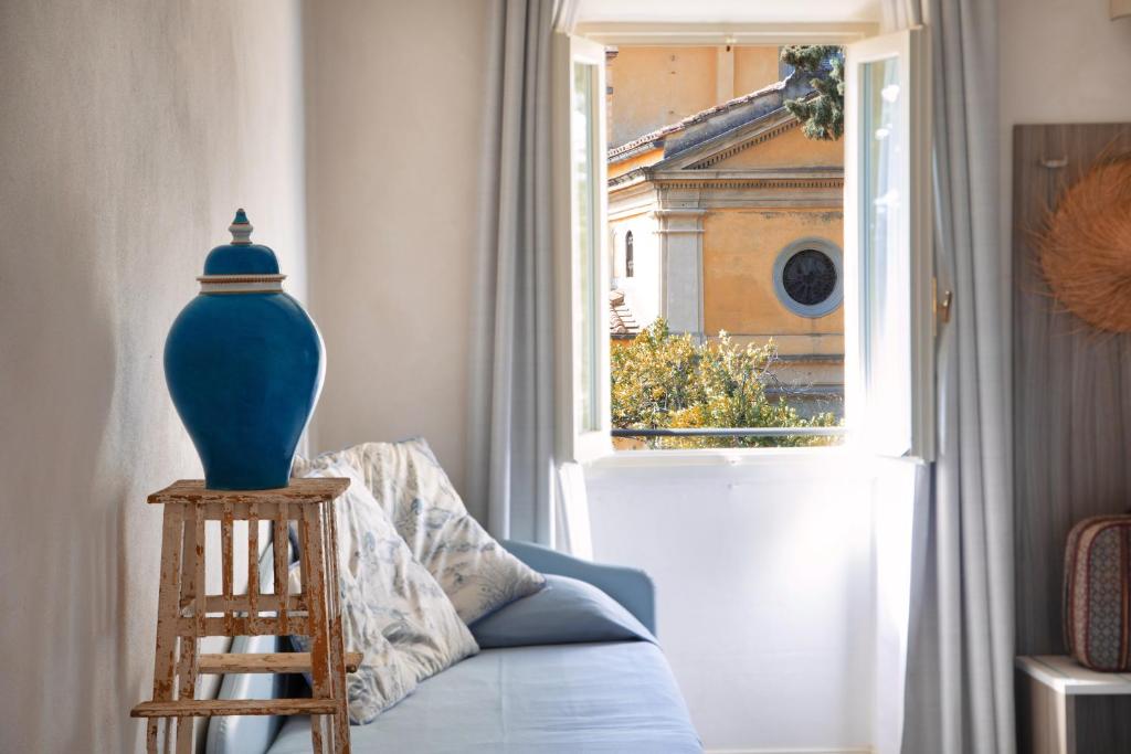菲耶索莱法托利亚麦阿诺旅馆的蓝色的花瓶坐在窗边的蓝色沙发上