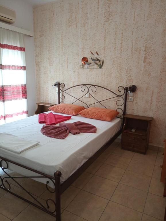 富尔尼群岛Nektaria on the Beach的一间卧室配有带白色床单和橙色枕头的床。