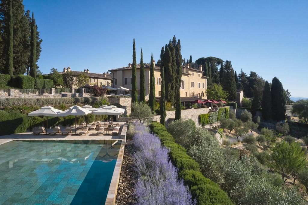 Castiglione del Bosco托斯卡尼瑰丽酒店的一座带游泳池和大楼的度假村