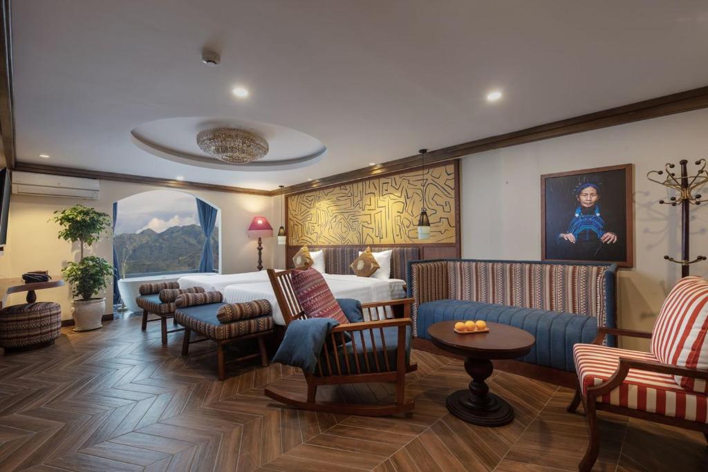 萨帕HOTEL DE SAPA的酒店客房配有一张床、一张沙发和椅子。