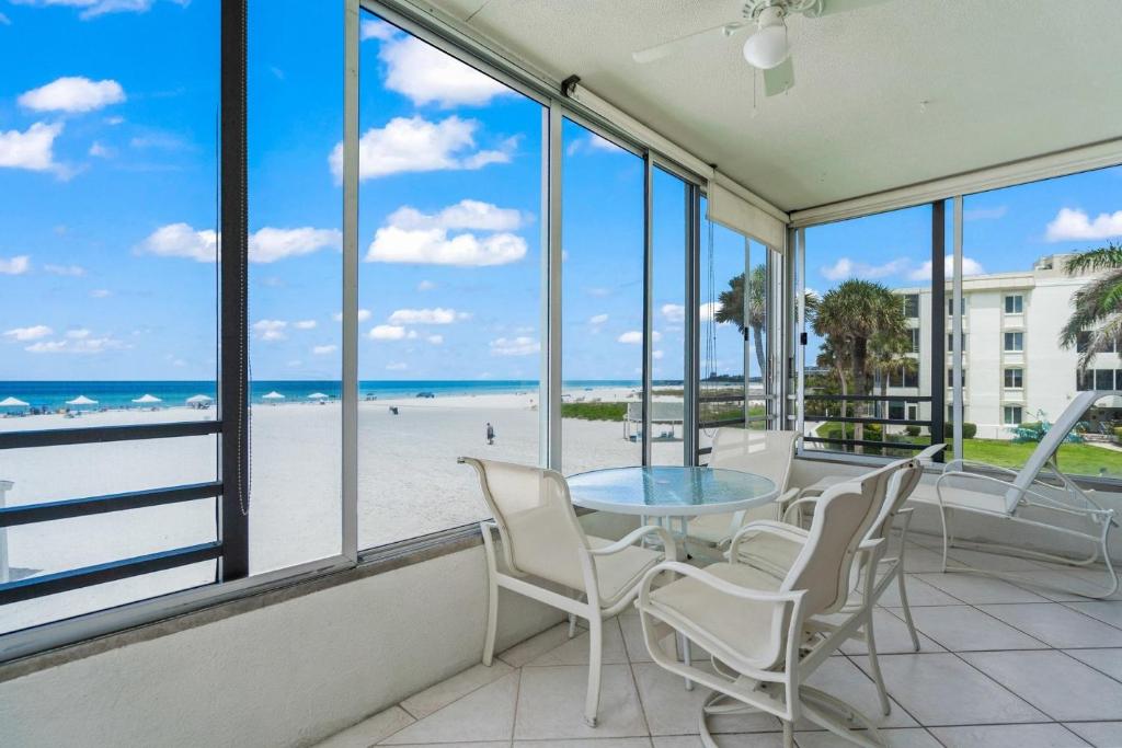 西耶斯塔岛Island House Beach Resort 3S的一间带桌椅和海滩的用餐室