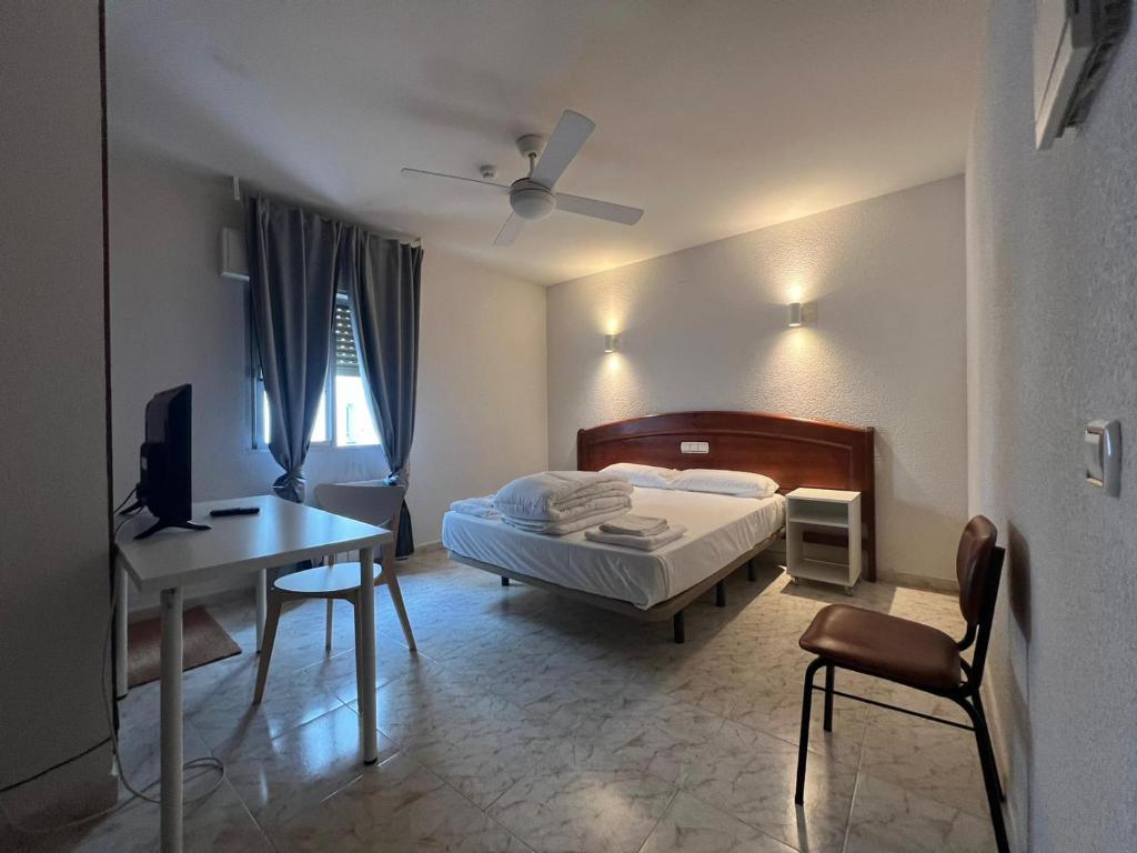塔拉韦拉·德·拉·雷纳拉埃姆巴雅达旅馆的一间卧室配有一张床、一张桌子和一张桌子