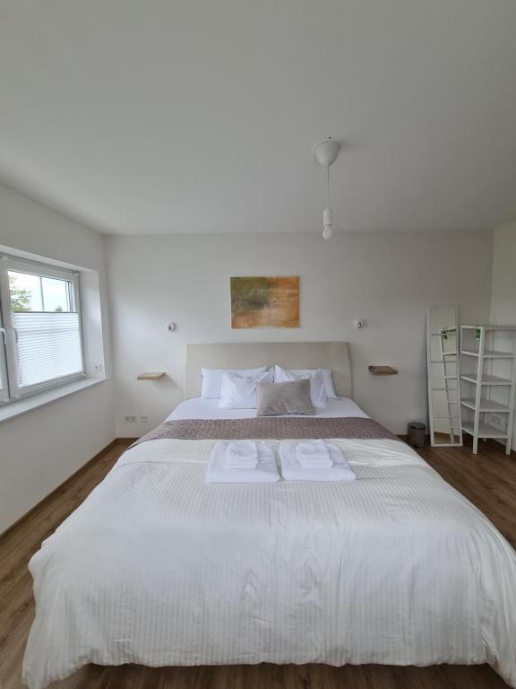 阿尔斯费尔德Private Zimmer in Neubau Familienhaus的卧室配有一张白色大床和两条毛巾