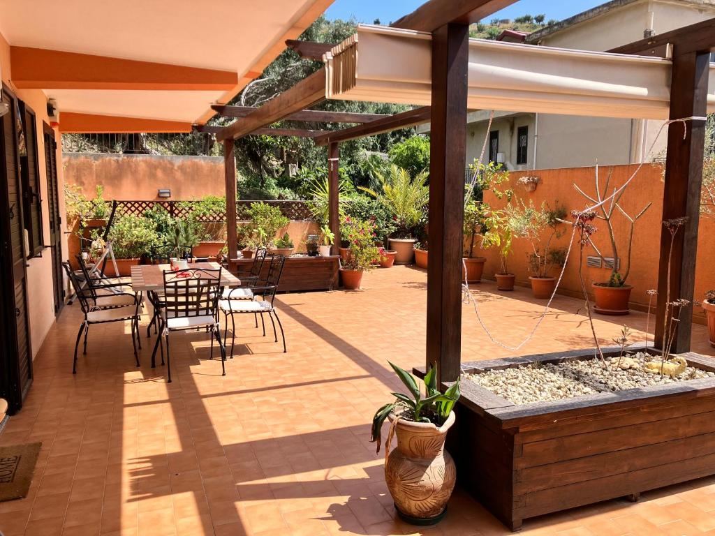 墨西拿La casa dell'Asparago的庭院配有桌椅和遮阳伞。
