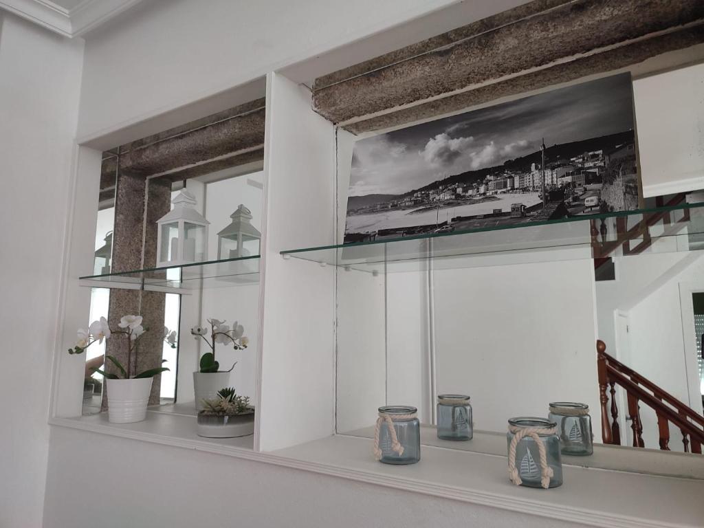 拉赫Piso Sol的一间房间,在架子上设有一扇带花瓶的窗户