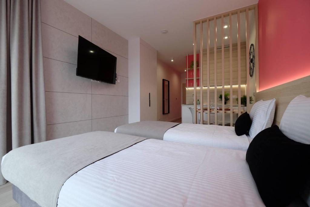 比亚韦斯托克Apartamenty Centrum的两张床铺,位于酒店客房,墙上配有电视